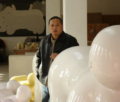 Pang Yongjie dans son atelier, devant une de ses sculpture